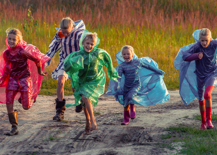 A group of running children in raincoats